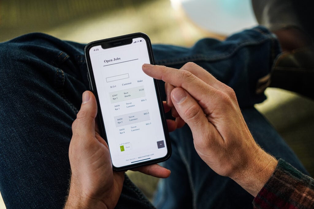 An EverLogic Mobile Dealership Software user views assigned service jobs on a smartphone.