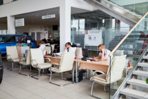 Vologda, Russia - June 18, 2019: Manager In Showroom With Cars O | EverLogic RV Dealership Software dealership employees working at their desks